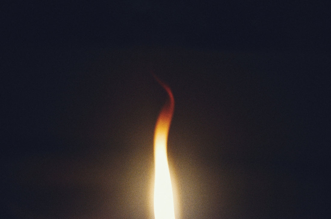 A single flame burning against a dark background