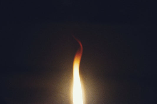 A single flame burning against a dark background
