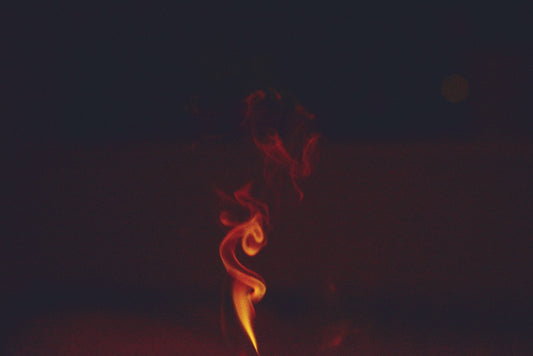 Orange smoke swirls against a dark background.