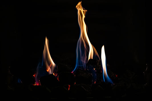 Flames dance in the darkness with blue and yellow hues